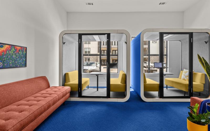 a room with a glass door and a couch and chairs